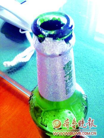 　　瓶口破损处为老伤，瓶内啤酒含大量白色沉淀。