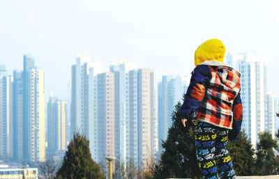 天津，一位儿童站在假山上观楼。