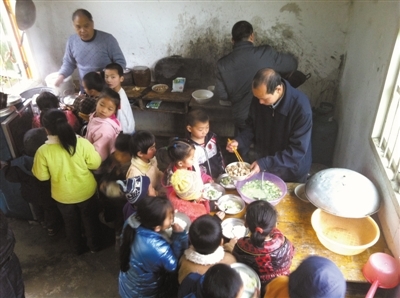 　　3月13日，广西那坡县弄汤村小学，老师在厨房给孩子们盛菜盛饭。该校校长表示，他是因为考虑厨房人手不够，且担心厨房食品安全问题，才向企业选购水牛奶。本报记者 李超 摄