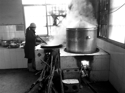 3月12日，广西那坡县念井小学，冯艳在学校食堂为学生做午饭。