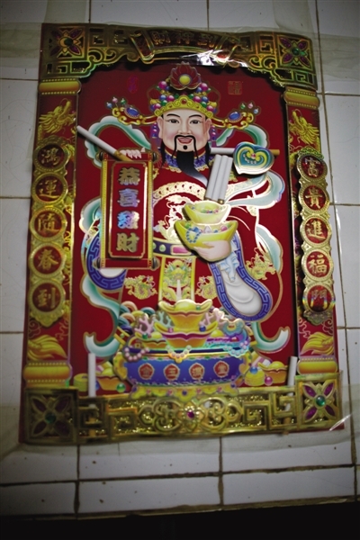 一家彩票店内，财神爷被供上香烟。