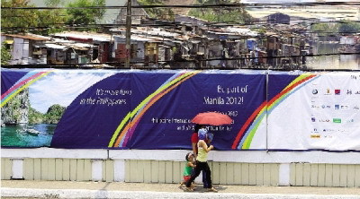 　　5月3日，菲律宾马尼拉，居民经过被海报覆盖的墙壁。图/IC