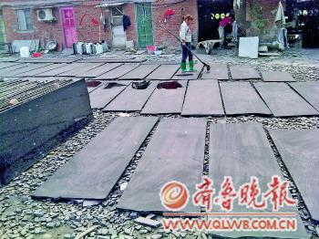 　　一名工人正在给石板上黑色染料。　　本报记者 任志方 摄