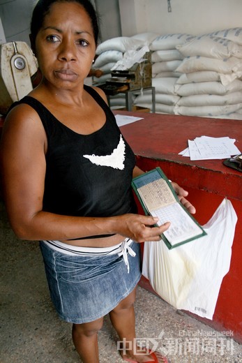 4月10日，哈瓦那一名市民拿着供应本购买粮食。摄影/陈君