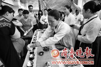 20日，来自韩国参展团的韩国友人为参加绿茶节的市民沏茶。　