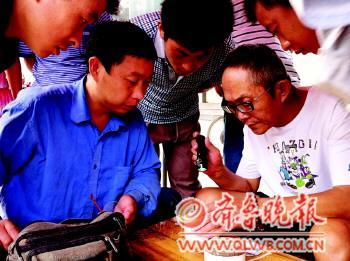 　　买家仔细检验蛐蛐时，都会引来众人的关注。