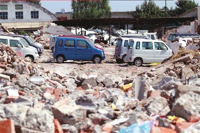 　　<b>上图：被拖出店内的新车停放在一片废墟上。</b>