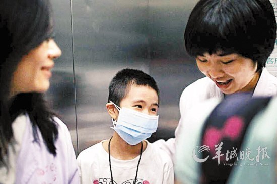 2012年4月12日上午，广州南方医院，电梯里，小碧心和护士阿姨开起了玩笑 孟祝斌 摄