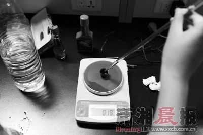　　给实验用的93号汽油样本称重。