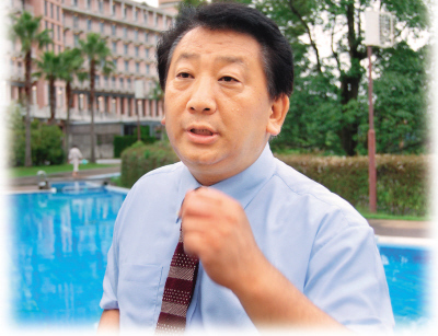 　　露崎强站在新收购的酒店前接受采访