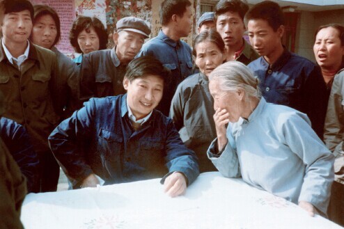 1983 年，时任中共正定县委书记习近平在大街上听取来访群众的意见。