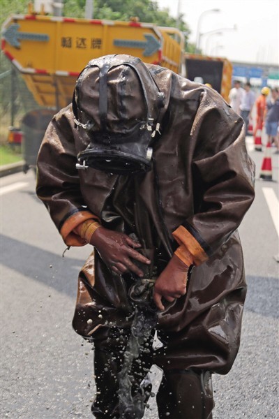 同事用水枪将潜水服上的淤泥冲刷干净.