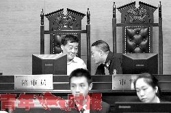 宗庆后不时与审判长低头耳语进行交流。