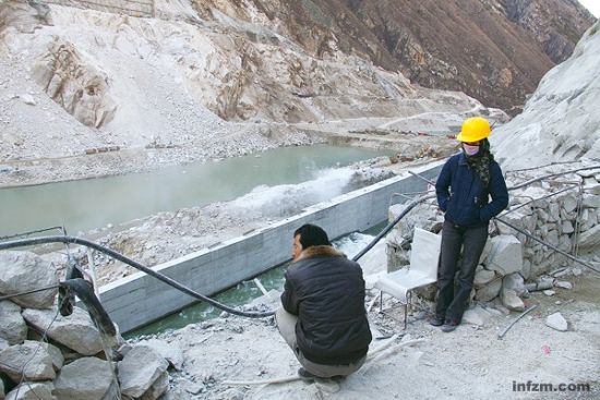 　　工人在半山遥望施工中的藏木水电站，江水从一侧的人工通道奔腾而下。 (南方周末记者 何海宁/图)