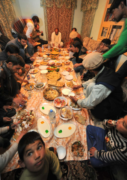 长长的席地餐前，平安归来的阿富汗人正在家中共享晚餐。晨报记者 陈征 摄影