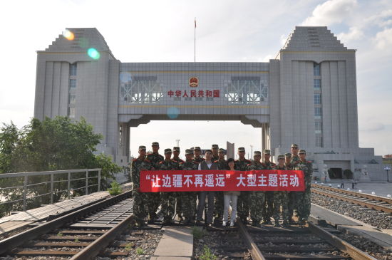 本报记者刘扬、谭利娅与满洲里口岸国门中队的战士们在国门前合影