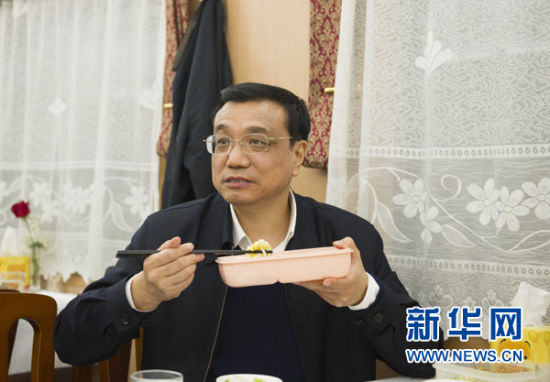 2012年12月28日，李克强在从当阳前往恩施的火车上吃盒饭。 新华社发