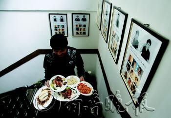 厨师魏江有时传菜，楼上楼下跑得很辛苦，但是他说自己很快乐。