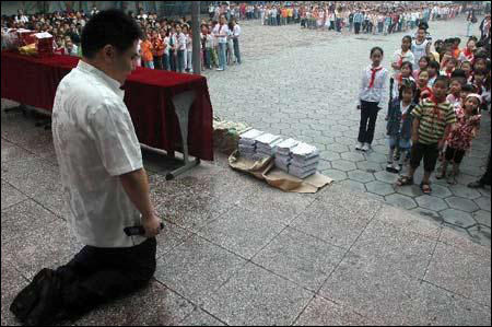 校长下跪赠学生10万本《弟子规》(图)