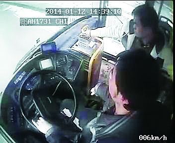 图为当事男乘客正往投币箱里投钞票。