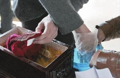 4月12日，骨灰移交现场，家属将亲人骨灰从骨灰盒中取出，装进海葬专用环保袋