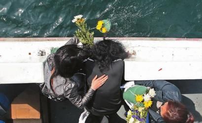 4月29日，家属将带有鲜花的亲人骨灰投入大海 