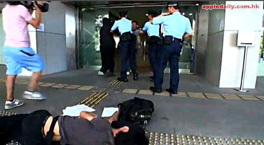 招显聪倒地。记者快速走过，拍摄打人者