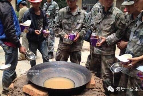 图为救援人员排队等候水开泡面充饥