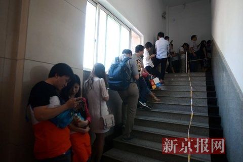 等待登记结婚的新人从三楼的办公大厅一直排队到一楼的马路上。