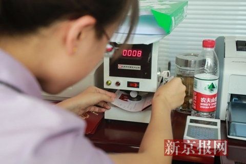 工作人员在结婚证上加盖钢印。