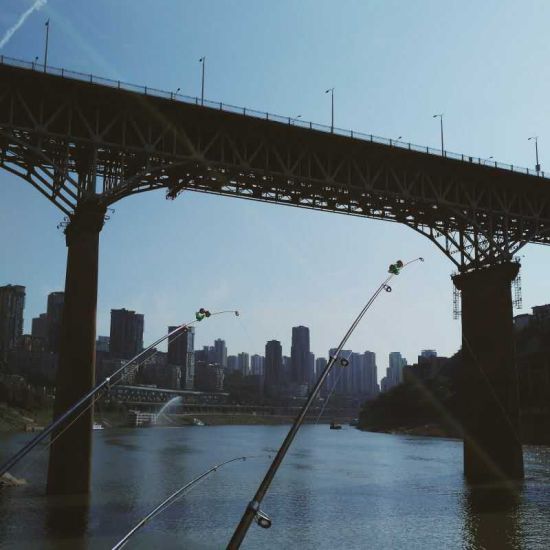 　　组图《大城小事》之一：鱼竿、阳光、江水还有山城，这些“重庆元素”都恰巧展现在这一画面中。摄影：刘志洁