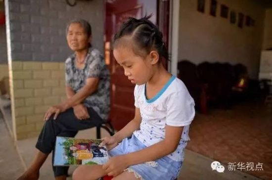 刘娜手里拿着妈妈和自己的合影仔细端详(7月28日摄)。