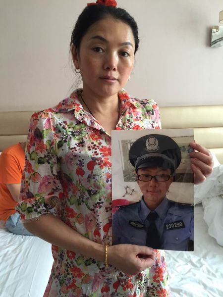 张宜碧拿着儿子雷驰的照片