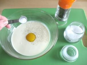 ⑴在一个大碗里打入鸡蛋，放入奶油、盐和胡椒，混合。