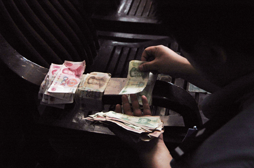 一妇女将数千元纸币撒入大观河