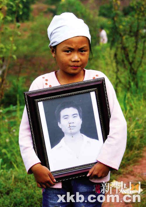 昨日早晨,金坪村8名遇难者集体出殡,一位小女孩抱着父亲遗像走在