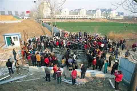 3月22日，平度市杜家疃村，村民在村南被征土地上围观被烧毁的帐篷。