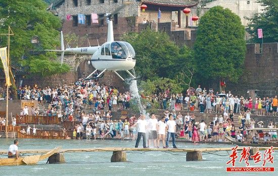 8月22日下午，凤凰古城沱江便桥上，叶文智父子和一对情侣接受冰桶挑战。 华声在线记者 徐行 摄