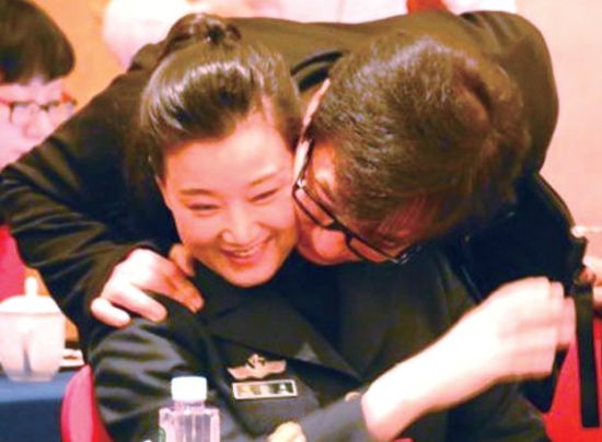 2014年全国“两会”期间，著名影星成龙走近“民歌皇后”宋祖英，从其身后抱住她并与之亲密地贴脸。