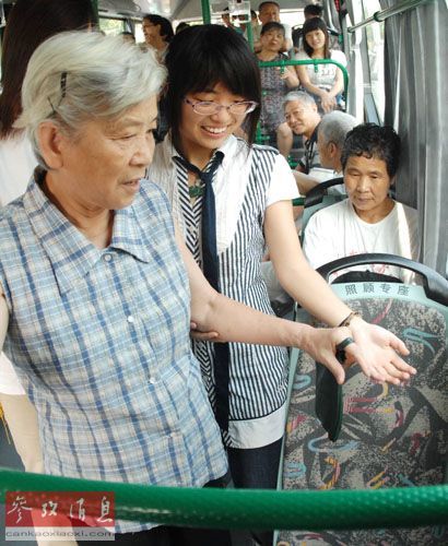 资料图：2008年7月14日，杭州开展“公交让座日”活动，倡导文明乘车、礼让座位。图为一名年轻乘客在公交车上为一位老人让座。 新华社发（胡冠华 摄）
