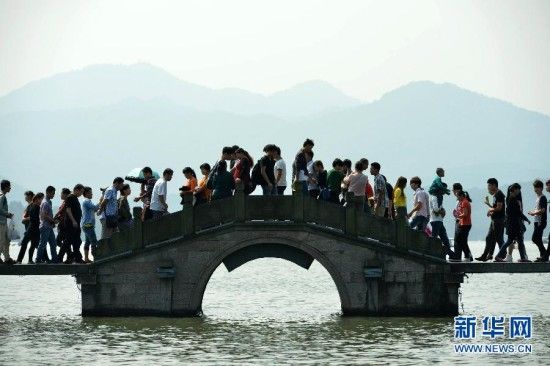 10月1日，游客在杭州西湖栈桥上游览。新华社发（龙巍 摄） 