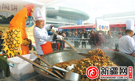 10月26日，在第四届中国清真美食文化节现场，农家土鸡焖饼展位的厨师用直径1.8米的大锅烹制土鸡焖饼。