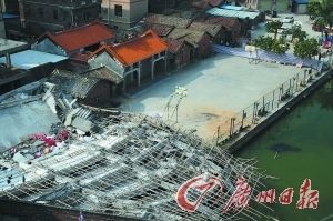 大楼坍塌后，整体倒向后方水塘。  