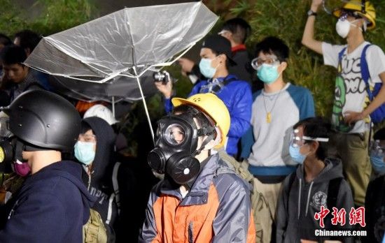 　香港违法“占领中环”持续53天，11月19日凌晨一批激进示威者发起暴力冲击，用铁栅栏、水泥砖块砸烂特区立法会大楼玻璃。中新社发 张宇 摄