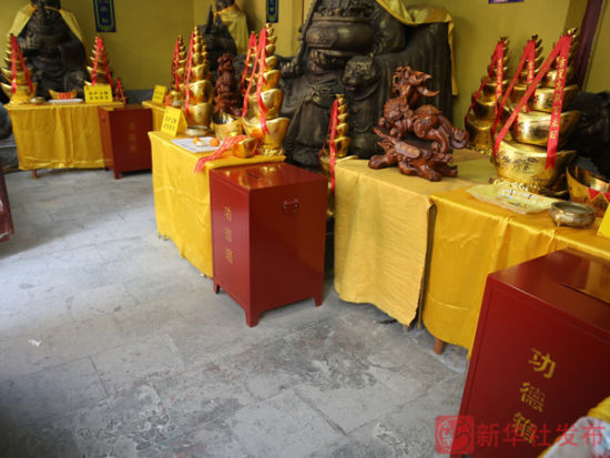 在北京潭柘寺一处售卖礼佛用品的摊位前，摆放着景区设置的功德箱（11月28日摄）。新华社发布客户端记者李德欣摄