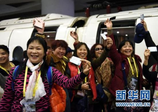 12月26日，一群广州游客在广州南站准备登上首趟广州开往贵阳的动车。 新华社记者 刘大伟 摄