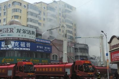 4日早上，另外一栋大楼也在起火，消防人员正在扑救。京华时报记者谭青摄