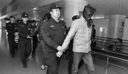 2014年12月16日，潜逃泰国的广东犯罪嫌疑人郑某等7人被押解回国 新华社发 