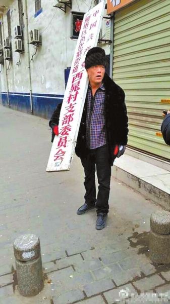 村民摘下村委会匾牌。微博截图