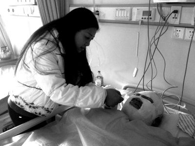 一位伤者头部和手臂被烧伤，其姑姑正在医院照看。京华时报记者 谭青 摄